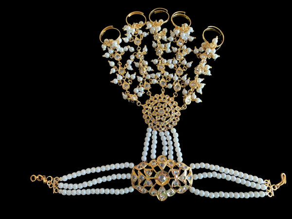 One of Deccan Jewelry’s HP7 Maya Haathphool, made with gold plating,  delicate strings of pearls, and teardrop patterns. The bracelet is made to fasten around the wrist, and extend to finger rings.