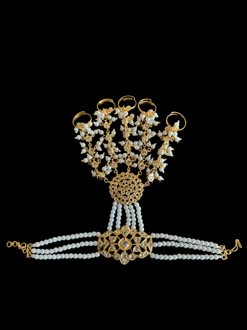 One of Deccan Jewelry’s HP7 Maya Haathphool, made with gold plating,  delicate strings of pearls, and teardrop patterns. The bracelet is made to fasten around the wrist, and extend to finger rings.