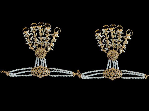 A pair of Deccan Jewelry’s HP7 Maya Haathphool, made with gold plating,  delicate strings of pearls, and teardrop patterns. The bracelet is made to fasten around the wrist, and extend to finger rings.